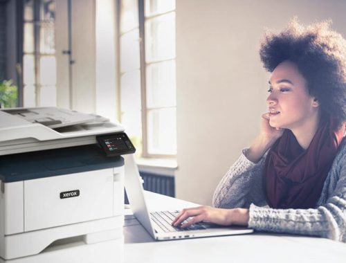 Young woman working at her computer next to a Xerox® B315 multifunction printer.