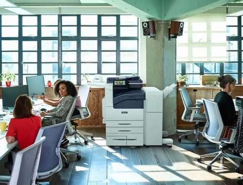 Team at work in an open space with the Xerox® VersaLink® B7100 Series monochrome printer