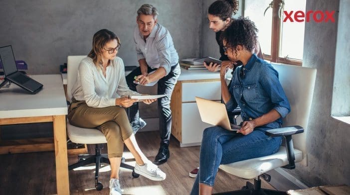 Four colleagues collaborating in a modern office.
